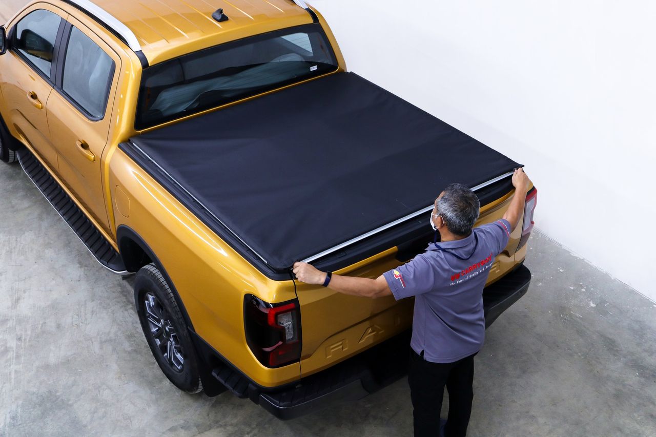 CARRYBOY technician fitting the Softlid to a yellow Ford Ranger