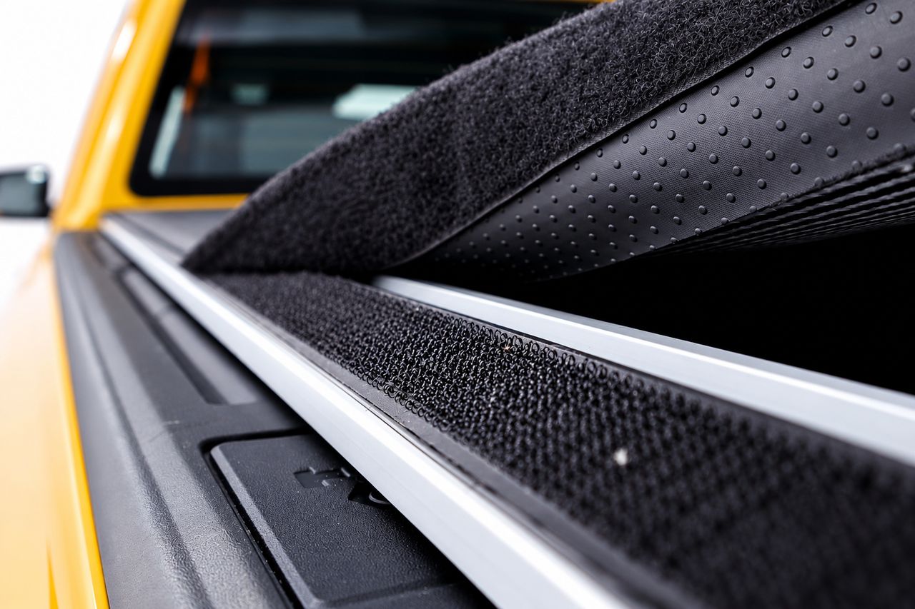 Close-up of the velcro strip along the side rail and the cover's textured underside