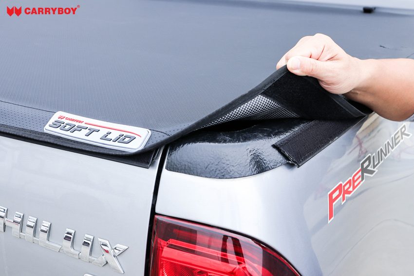 Hand lifting the Softlid Lite edge to show the velcro closure