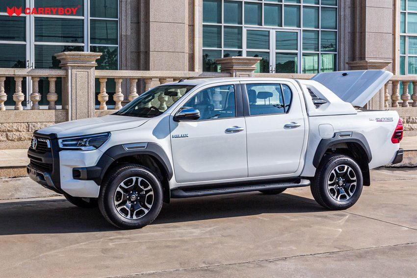 White Toyota Hilux with the Full Box lid raised, side view
